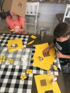 Next we cut out some shapes for windows. We wanted to give them a 3-D look, so we cut out the cardboard and construction paper.